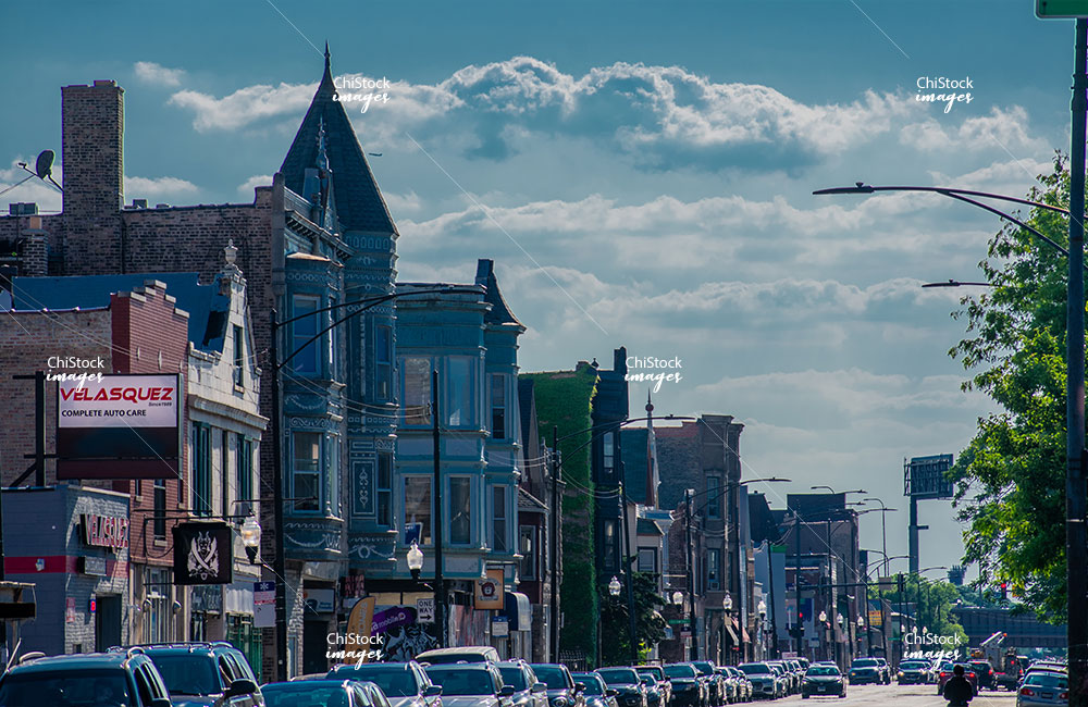 A street corner in Avondale, Chicago, showing a mix of classic brick buildings and local businesses.
