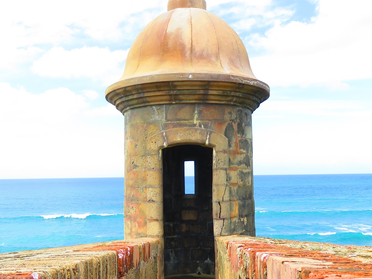 Stone sentry box turret of El Morro fort overlooking the deep blue sea