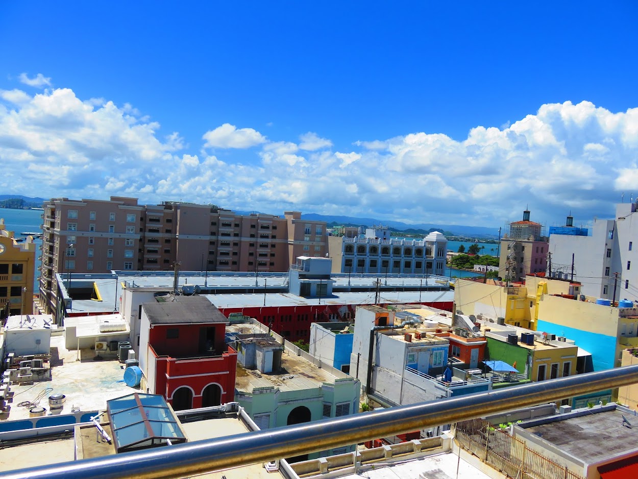 Rooftop view across colorful Old San Juan buildings toward the bay