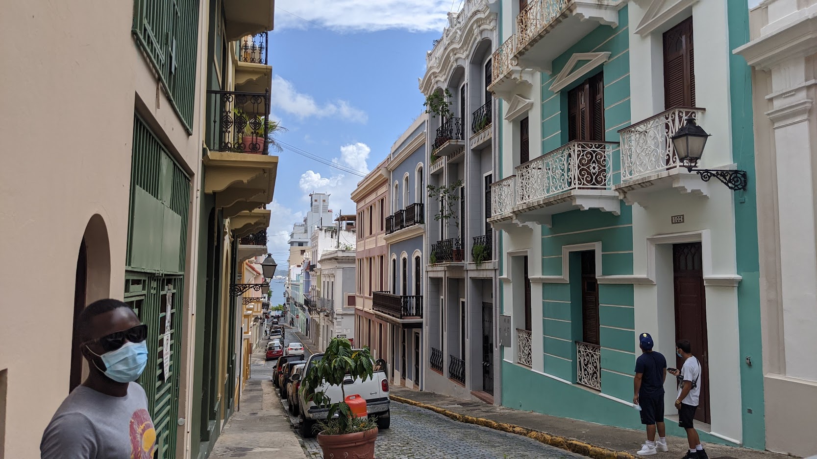 Narrow Old San Juan street lined with pastel colonial buildings and balconies