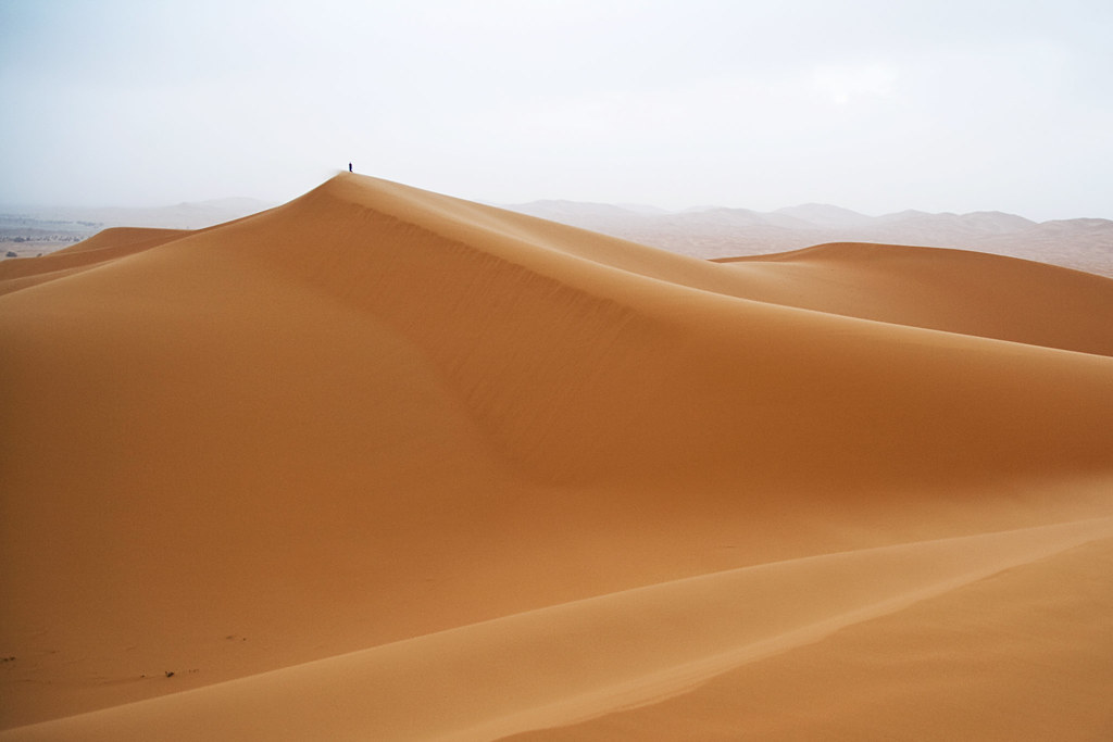 Sand dunes at Erg Chebbi in the Moroccan Sahara, a tiny figure on the ridge for scale